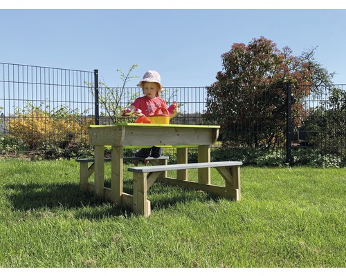 Kind an Holzsitzgruppe mit Sandkasten im Garten
