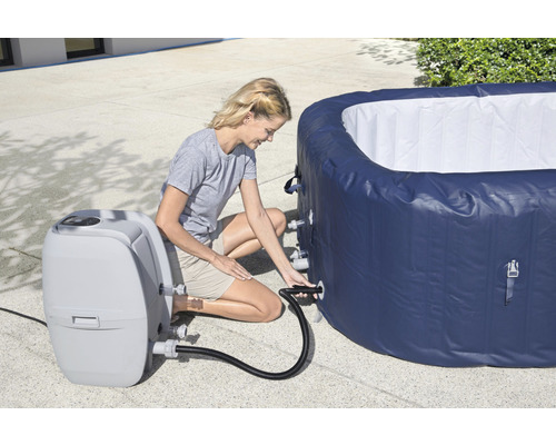Frau schließt aufblasbaren Whirlpool an das zugehörige Gerät an.