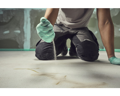 Handwerker trägt Estrich auf dem Boden auf