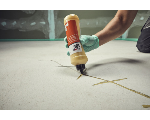 Handwerker trägt mit einer Kartusche Klebstoff auf einen Untergrund auf