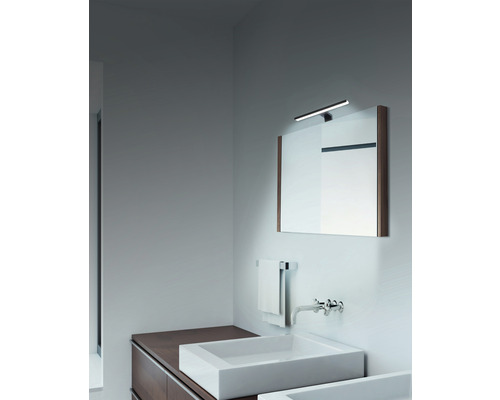 Badezimmer mit Waschbecken, Spiegel und Beleuchtung