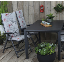 Gartenszene mit Esstisch und Klappstühlen mit floralen Auflagen
