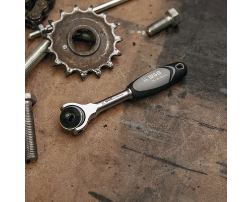 WGB Knarre neben Schrauben und Zahnrad auf einer Werkbank