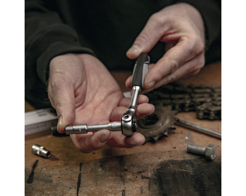 Nahaufnahme einer Person, die eine Steckschlüssel verwendet, um eine Schraube festzuziehen.