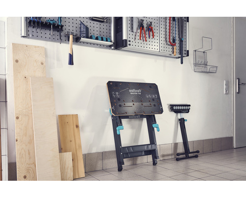 Werkstatt mit Werkbank, Werkzeugwand und Holzplatten