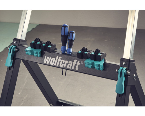 Wolfcraft Logo auf Arbeitstisch mit Schraubendrehern und Spannbacken