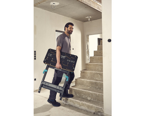 Mann trägt Wolfcraft Logo Klapptisch die Treppe hoch