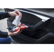 Feuchttücher zur Reinigung des Autoinnenraums in einer Hand