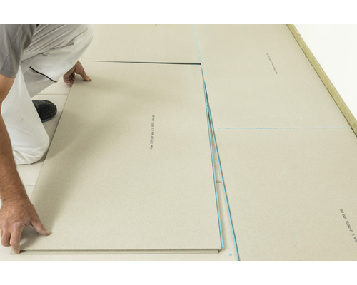 Mann verlegt Trockenestrichplatten auf dem Boden