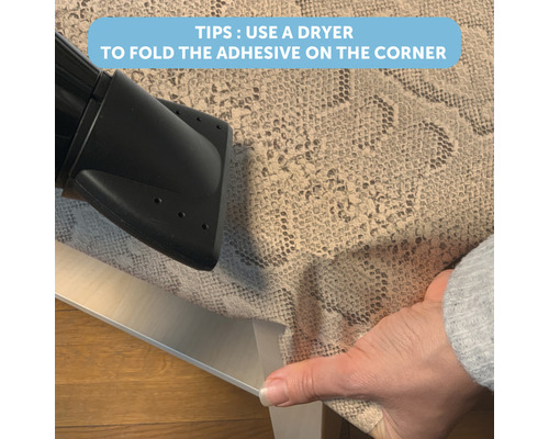 Anwendungstipp: Eine Person verwendet einen Fön, um eine Klebefolie um eine Tischecke zu falten.