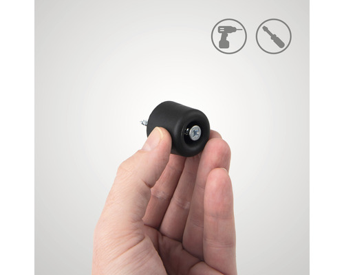 Eine Hand hält einen schwarzen Türstopper zur Montage mit Schraube. Installationssymbole im Hintergrund.