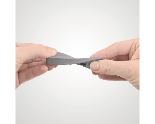 Eine Person biegt einen Türstopper aus Gummi.