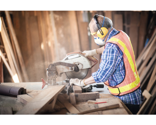 Handwerker mit Schutzmaßnahmen bei der Holzarbeit mit einer Kreissäge