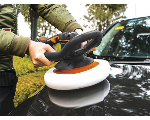 Eine Person poliert mit einer Poliermaschine ein Auto.