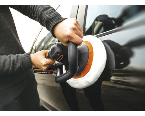 Eine Person poliert ein Auto mit einer Poliermaschine.