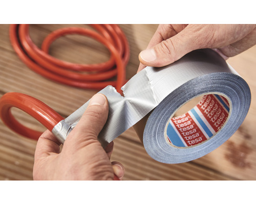 Eine Person repariert einen Schlauch mit Gewebeband.