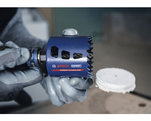 Bosch Expert Lochsäge in Händen mit Schutzhandschuhen.