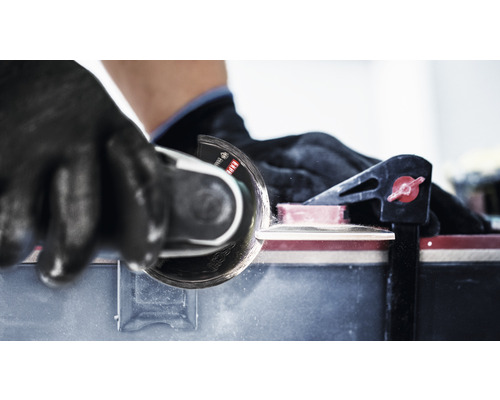 Fliesenschneider im Einsatz mit Handschuhen und Klemme