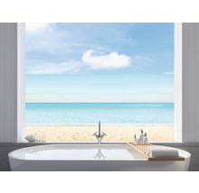 Helles Badezimmer mit Badewanne, Armatur, Badewannenablage mit Handtüchern und Blick auf den Strand