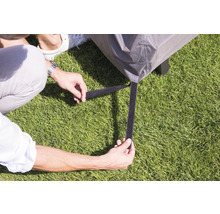 Person befestigt Schutzhülle mit Klettverschluss an Gartenmöbeln.