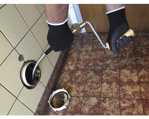 Rohrreinigungsspirale im Einsatz zur Abflussreinigung im Badezimmer