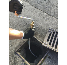 Ein Abflussreiniger wird in einen Gully eingeführt.