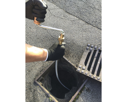 Ein Abflussreiniger wird in einen Gully eingeführt.