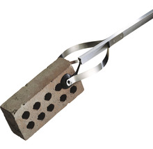 Steinzange hält einen Ziegelstein.