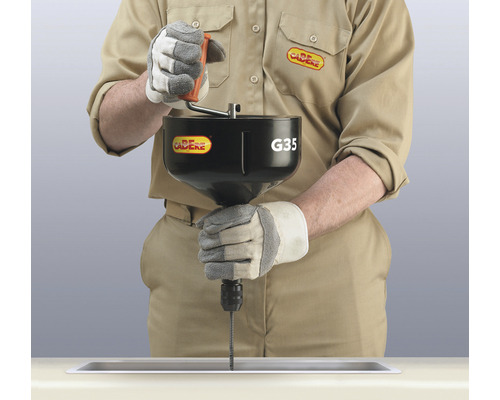 Person benutzt eine Rohrreinigungsspirale im Waschbecken