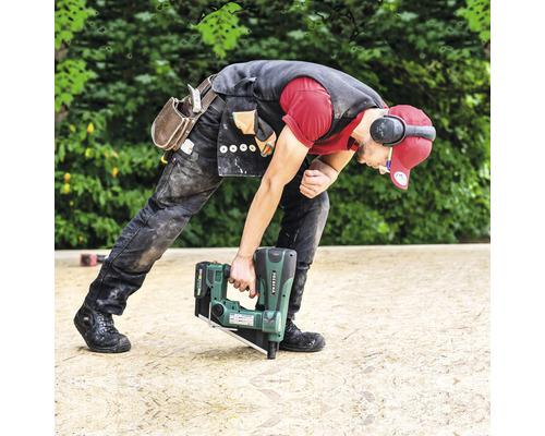 Ein Handwerker befestigt eine Holzplatte mit einem Akku-Nagler.