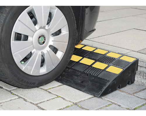Auto fährt über eine Bordsteinrampe aus Gummi mit gelben Markierungen