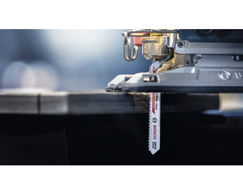 Nahaufnahme einer Stichsäge mit eingesetztem Sägeblatt beim Schneiden von Holz