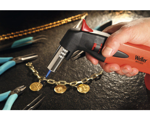 Detailaufnahme eines Weller Lötbrenners beim Bearbeiten eines Schmuckstücks, umgeben von Werkzeugen.