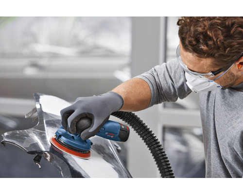 Ein Mann schleift ein Werkstück mit einem Exzenterschleifer von Bosch