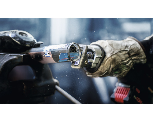 Rohr in Schraubstock eingespannt wird mit einer Säbelsäge geschnitten