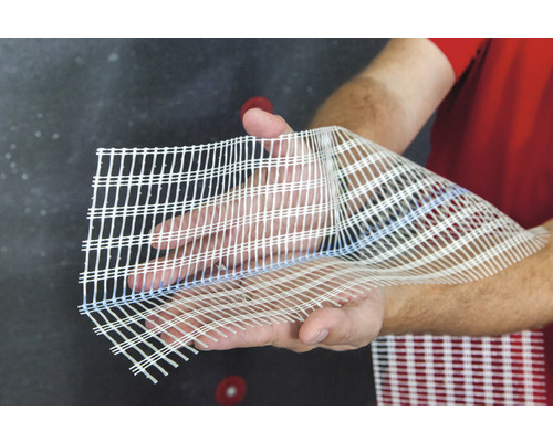 Eine Person hält ein Armierungsgewebe in der Hand.