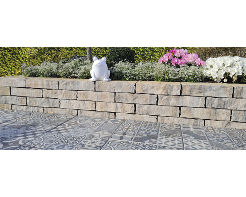 Gartenlandschaft mit Steinmauer, dekorativen Fliesen und Pflanzschmuck