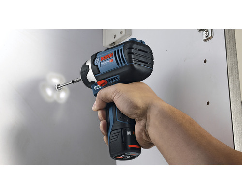 Eine Person benutzt einen Akku-Schlagschrauber, um eine Schraube in ein Objekt zu schrauben. Bosch Logo.