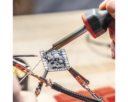 Löten einer elektronischen Platine mit Lötkolben und Haltevorrichtung