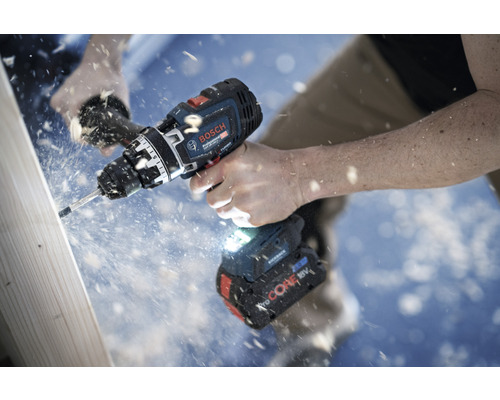 Eine Person bohrt mit einem Akku-Bohrschrauber von Bosch in ein Holzbrett.