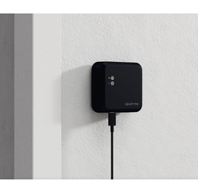 Iqloohome Logo mit angeschlossenem USB-Kabel an einer Wand