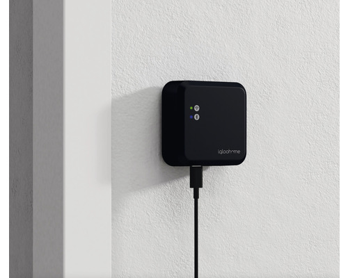 Iqloohome Logo mit angeschlossenem USB-Kabel an einer Wand