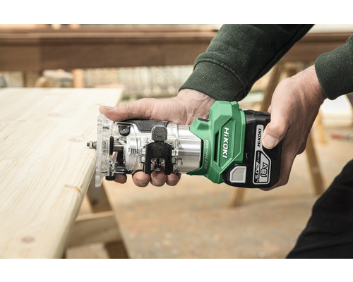 Personen halten eine Akku Oberfräse von HiKoki über ein Holzbrett.