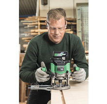 Handwerker mit Schutzbrille und Gehörschutz beim Arbeiten mit einer Oberfräse an einem Holzstück.