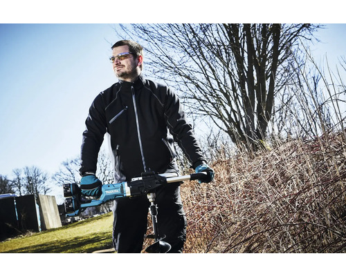 Ein Mann benutzt einen Erdbohrer der Marke Makita im Freien.