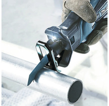 Eine Handsäge schneidet ein Metallrohr
