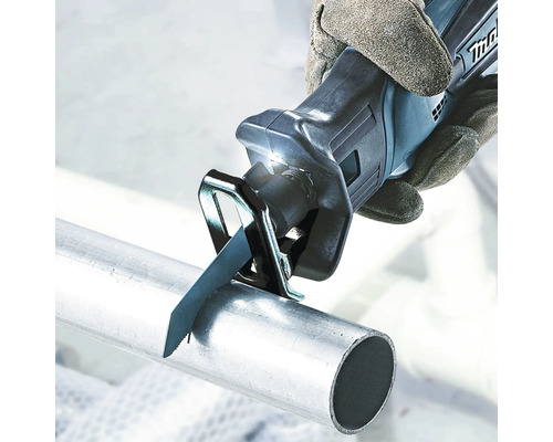 Eine Handsäge schneidet ein Metallrohr