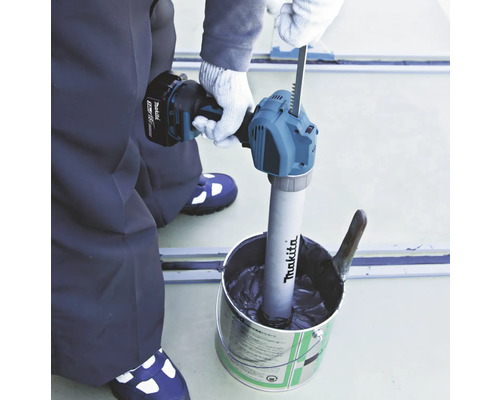 Handwerker mischt Material mit einem Makita Rührgerät in einem Eimer.