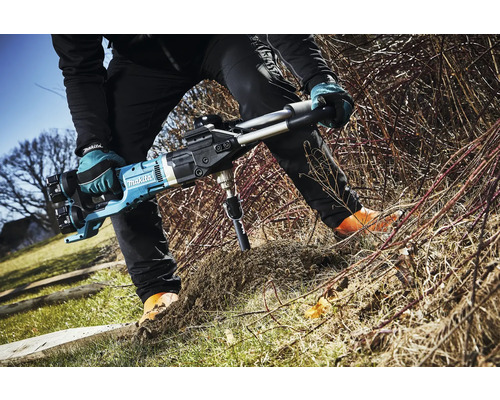 Person bohrt mit einem Makita Erdbohrer ein Loch in den Boden.
