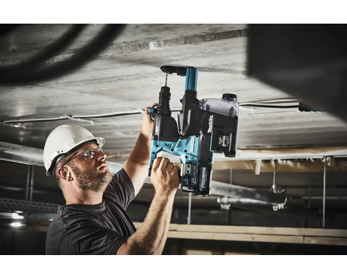 Ein Mann bohrt mit einem Akku-Bohrhammer von Makita in eine Betondecke.